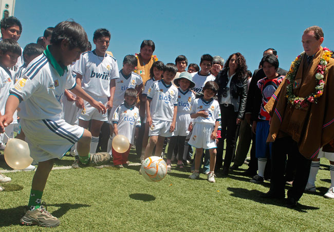 El ex futbolista español Emilio Butragueño, juega con niños durante la inauguración de la Escuela del Real Madrid en la ciudad de El Alto. Foto: EFE