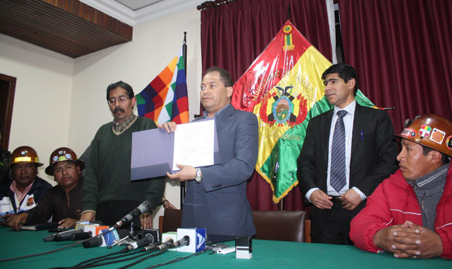 El ministro Carlos Romero muestra el acuerdo firmado entre mineros cooperativistas y sindicalizados. Foto: ABI