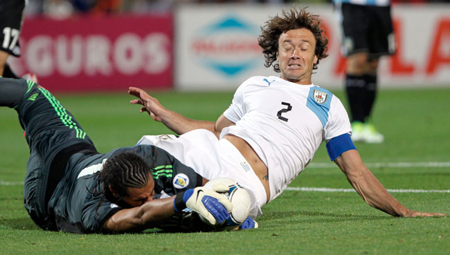 El uruguayo Diego Lugano en el choque que le valió la tarjeta amarilla, contra el portero argentino Sergio Romero. Foto: EFE