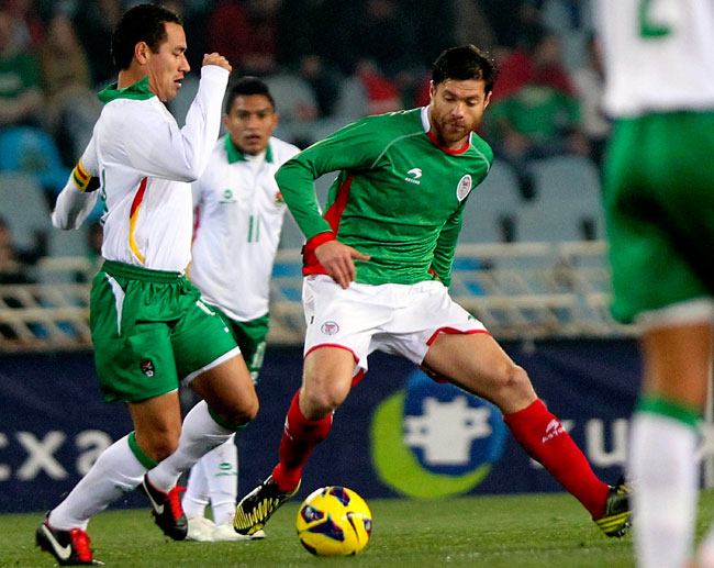 El jugador de la selección autonómica de Euskadi, Xabi Alonso (d) controla el balón ante Gualberto Mojica, de la selección de Bolivia. Foto: EFE