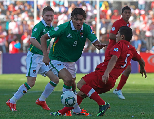 El boliviano Marcelo Martins Moreno disputa el balón con el peruano Joel Sánchez. Foto: EFE