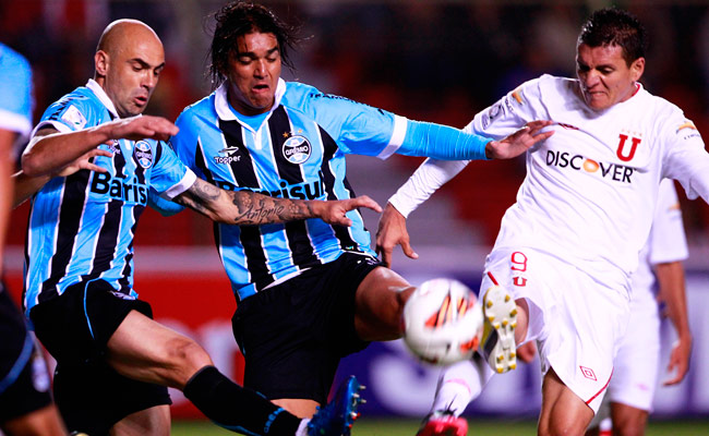Carlos Garcés (d) de Liga de Quito disputa el balón con Marcelo Martins (c) y Cris (i), de Gremio, en el partido de ida entre ambos equipos por la Copa Libertadores. Foto: EFE
