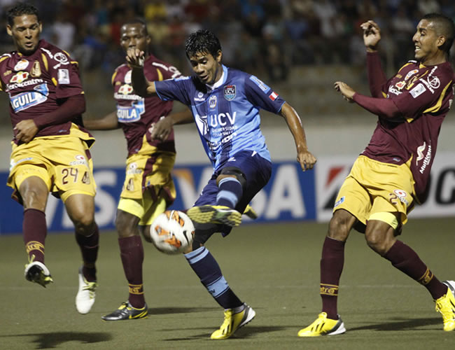 Henry Quinteros (c), disputa la pelota con los jugadores, Félix Nogupia (i) y Davinson Monsalve (d), del Tolima. Foto: EFE