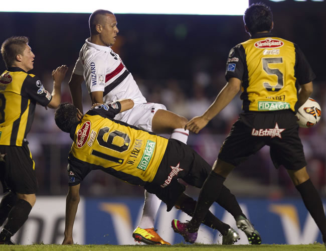 El jugador de Sao Paulo Luis Fabiano (c) disputa el balón con jugadores de The Strongest. Foto: EFE