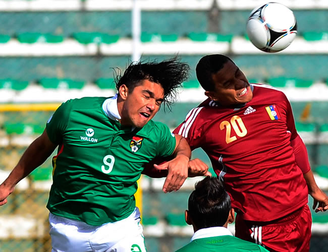 El boliviano Marcelo Moreno (i) disputa el balón con el venezolano Grenddy Perozo (d). Foto: EFE