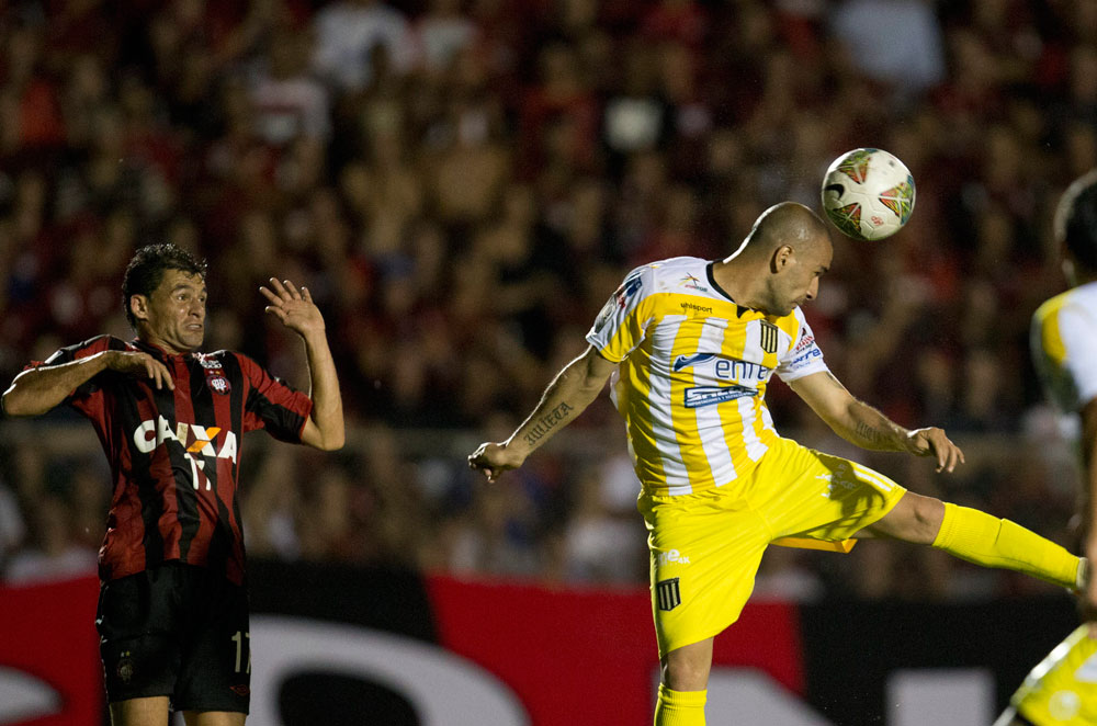 El jugador de The Strongest Ernesto Cristaldo (d) cabecea el balón ante la marca de Paulo Dias (i), de Atlético Paranaense. Foto: EFE