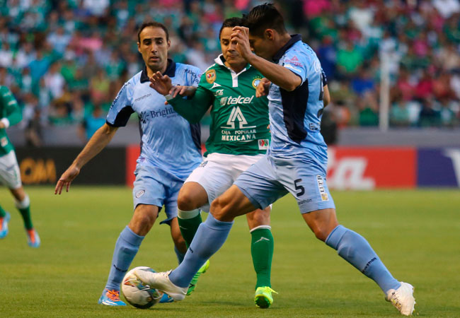 El jugador del León de México Luis Arturo Montes (c) disputa el balón con José Luis Capdevila (i) y Luis Gutiérrez (d) de Bolívar. Foto: EFE