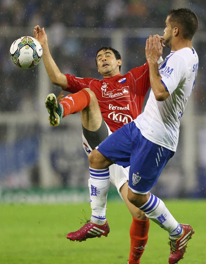 El jugador de Vélez Sarsfield de Argentina Héctor Canteros (d) ante Raul Piris (i) de Nacional de Paraguay. Foto: EFE