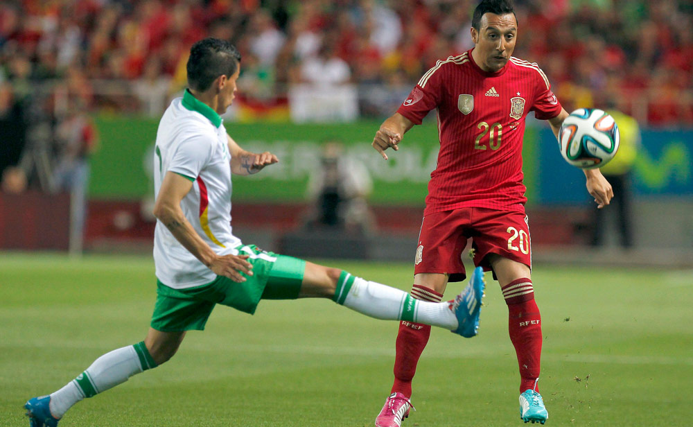 El jugador boliviano Marbin Bejarano trata de interceptar un pase al español Santi Cazorla. Foto: EFE