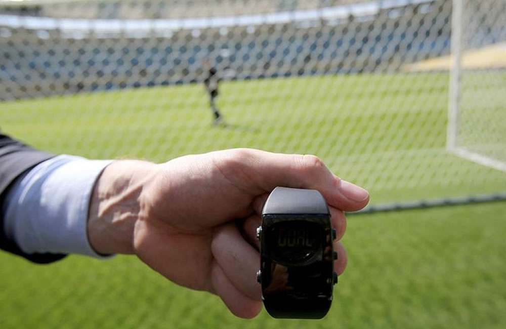 Un representante de la FIFA muestra un reloj que recibe avisos de cámaras ubicadas en los estadios. Foto: EFE