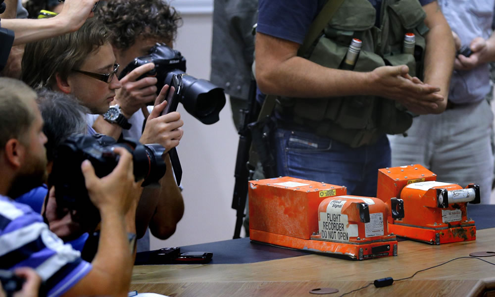 Periodistas toman imágenes de las dos cajas negras del vuelo MH17 de Malaysian Airlines. Foto: EFE