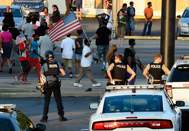 Policías vigilan una manifestación por la muerte del joven Michael Brown, quien murió por disparos de un policía, en Ferguson, Misuri (EEUU). Foto: EFE