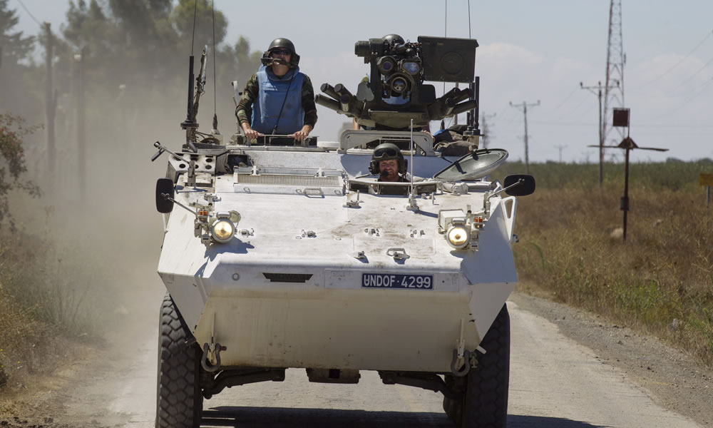 Miembros de las fuerzas observadoras de la ONU circulan con sus vehículos militares a su llegada a la base de la ONU en la ciudad de Quneitra. Foto: EFE