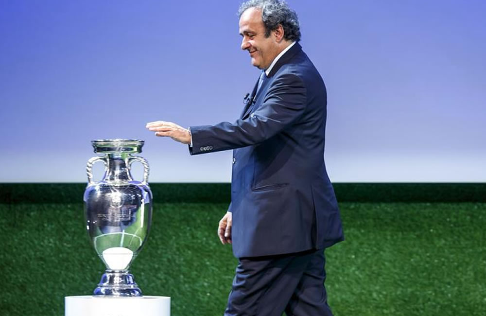 El presidente de la UEFA, Michel Platini, hace el gesto de tocar el trofeo de la Liga de Campeones. Foto: EFE