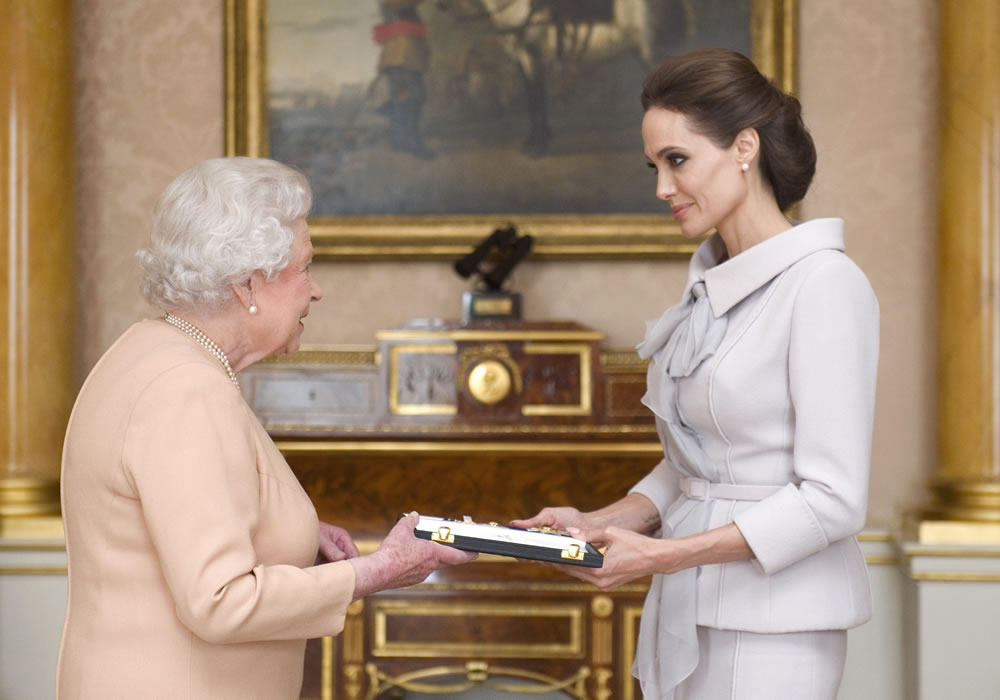 Reina Isabel II nombrando "dama de honor" a la actriz Angelina Jolie. Foto: EFE