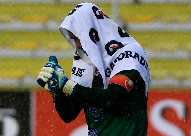 El arquero Daniel Vaca de The Strongest exprime sus guantes por la persistente lluvia. Foto: EFE