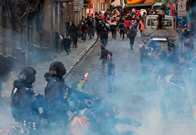 Policías tratan de dispersar con gases lacrimógenos a un grupo de mineros que intentaban ingresar a la plaza Murillo en la ciudad de La Paz. Foto: ABI