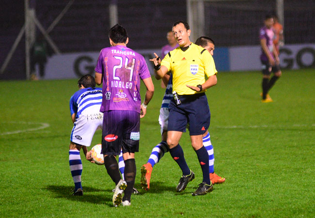 El árbitro Darío Herrera llama la atención de Carlos Hidalgo de Real Potosí, en el partido ante Atético Juventud. Foto: EFE