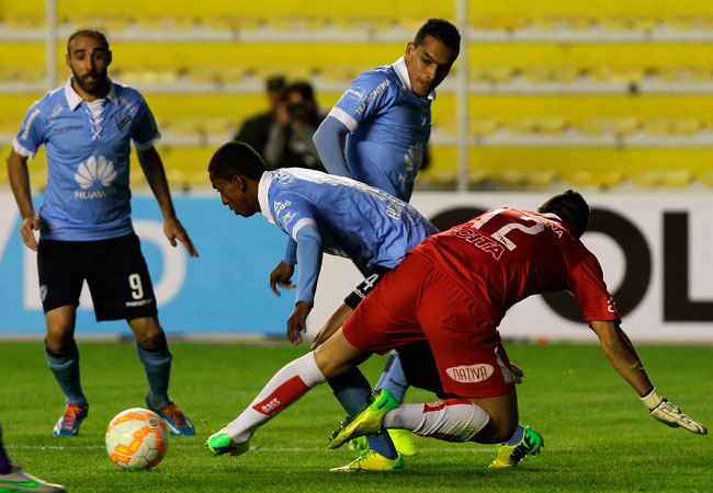 El jugador de Bolívar, Jaime Arrascaita (c) trata de superar al guardameta Martín Campaña (d) de Defensor Sporting. Foto: EFE