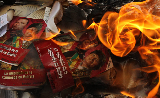 Fabriles de La Paz quemaron ante el Ministerio de Trabajo afiches y libros con la imagen del presidente Evo Morales. Foto: EFE