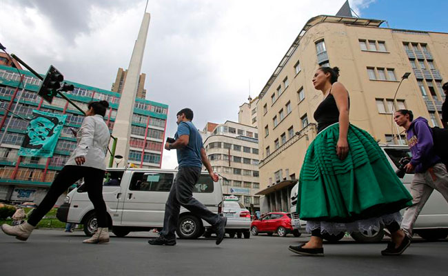 María Saenz (d) realiza una intervención artística callejera en El Prado de la ciudad de La Paz. Foto: EFE