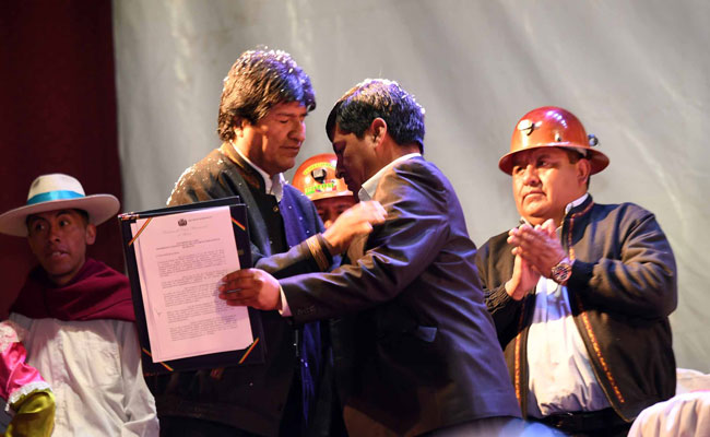 El presidente Evo Morales entrega un decreto, que manda la construcción de una cementera en Potosí, al gobernador Juan Carlos Cejas. Foto: ABI