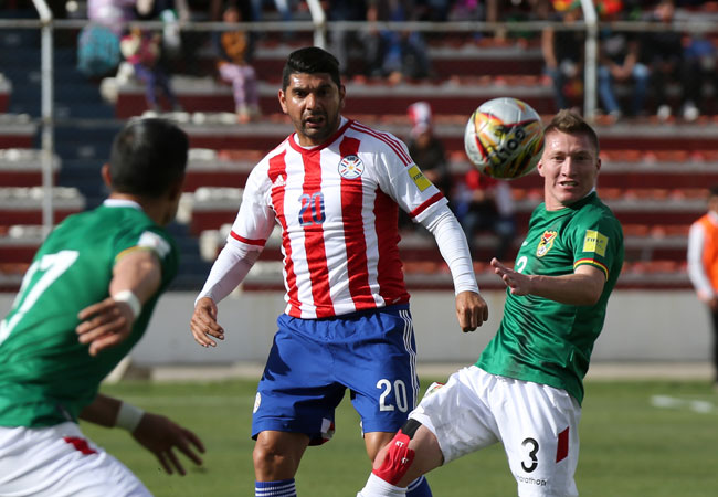 Los jugadores Alejandro Chumacero (d) y Néstor Ortigoza (c) de Bolivia y Paraguay respectivamente en disputa por el balón, en el encuentro jugado el jueves en La Paz. Foto: EFE