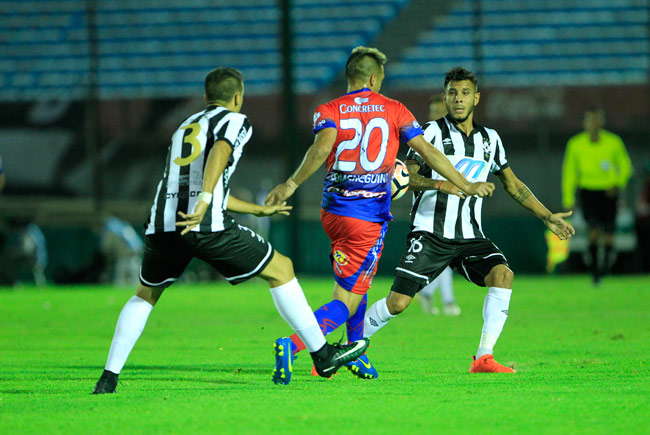 El jugador del Universitario de Sucre Anibal Domeneghini (c) disputa el balón con Emiliano Díaz (i) y Mauricio Gómez (d) de Wanderers. Foto: EFE