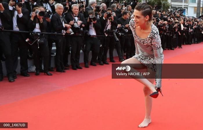La actriz estadounidense y miembro del jurado de largometrajes Kristen Stewart se quita los zapatos en la alfombra roja en pleno Festival de Cannes. Foto: AFP