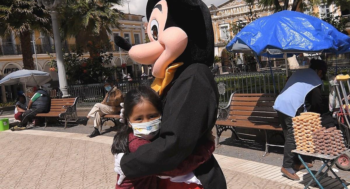Armando se disfraza de Mickey Mouse y reparte abrazos para ganarse la vida. Foto: EFE