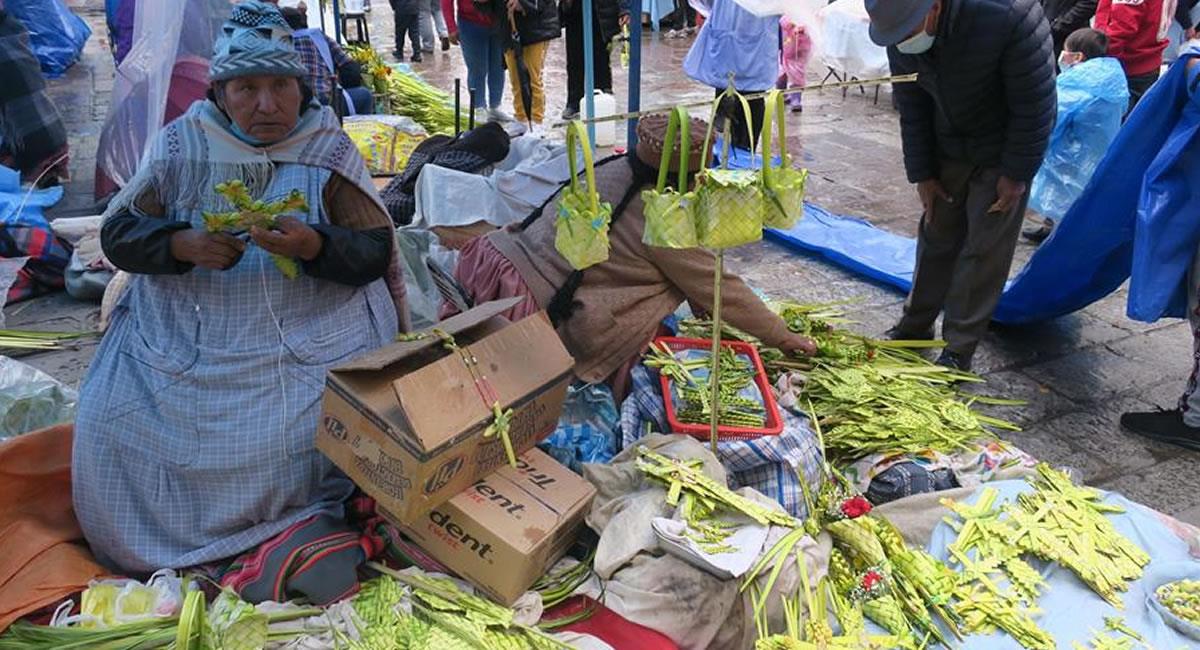Una mujer vendiendo palmas entrelazadas para la celebración del Domingo de Ramos. Foto: EFE