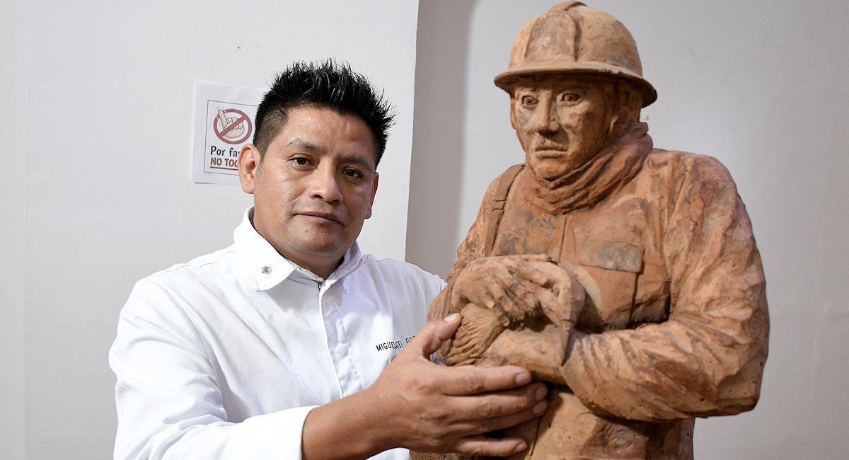 El chef y artista boliviano Miguel Ángel Figueroa posa junto a una de sus esculturas. Foto: EFE