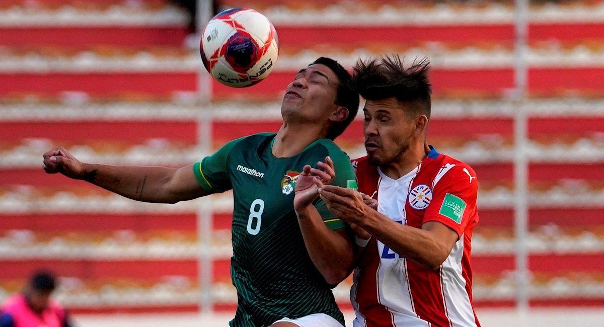 Diego Bejarano de Bolivia disputa un balón con Óscar Romero de Paraguay. Foto: EFE