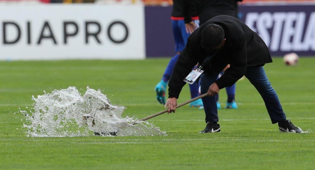 Staff del Hernando Siles sacando el agua de la cancha principal donde juega Bolivia vs. Chile. Foto: EFE
